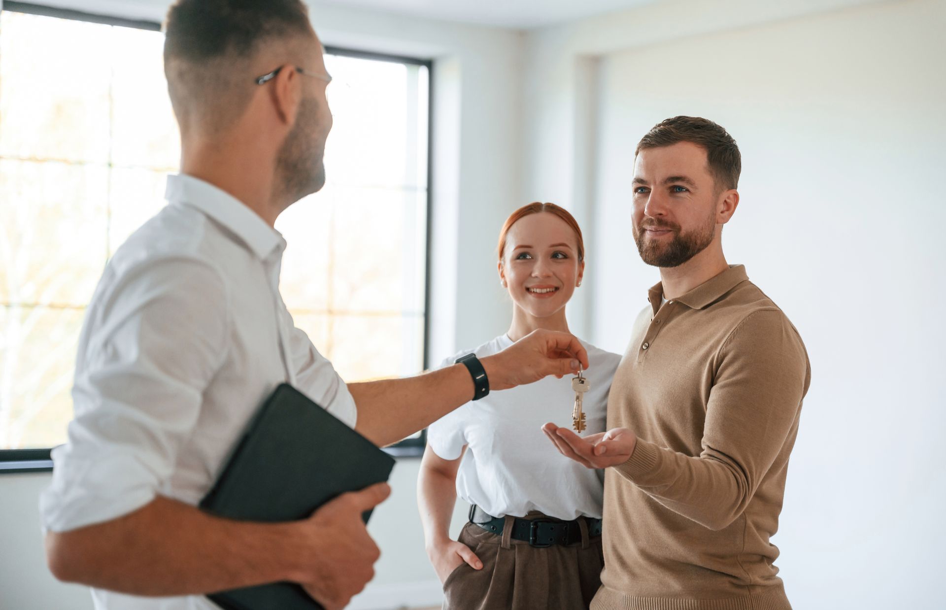 Une remise des clés de logement entre un propriétaire et ses locataires