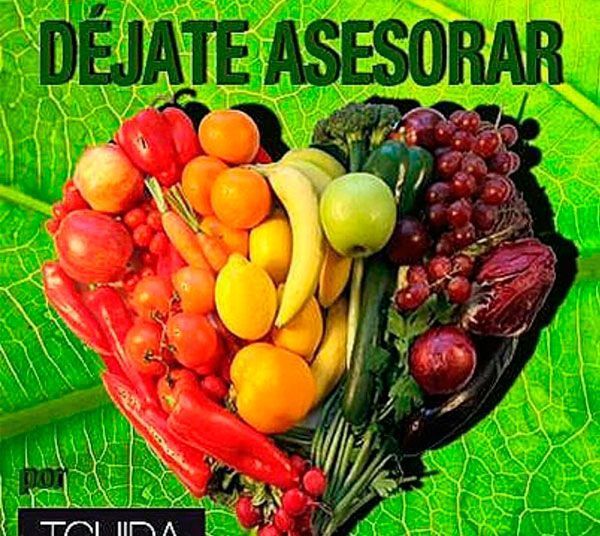 Un corazón hecho de frutas y verduras sobre un fondo verde.