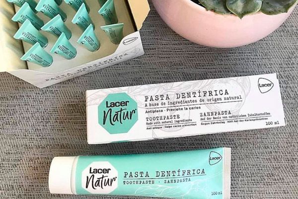 Un tubo de pasta de dientes está al lado de una caja de pasta de dientes.