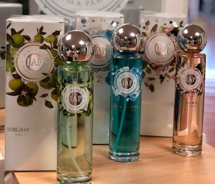 Tres frascos de perfume están uno al lado del otro sobre una mesa.