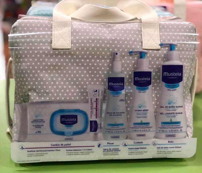 Una bolsa de bebé llena de productos para bebés Mustela