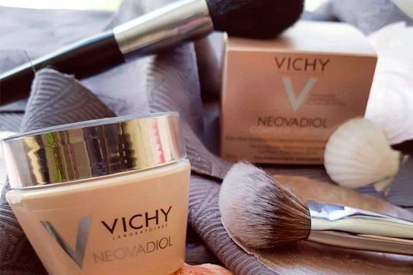 Un tarro de Vichy Neoradiol junto a unas brochas de maquillaje.
