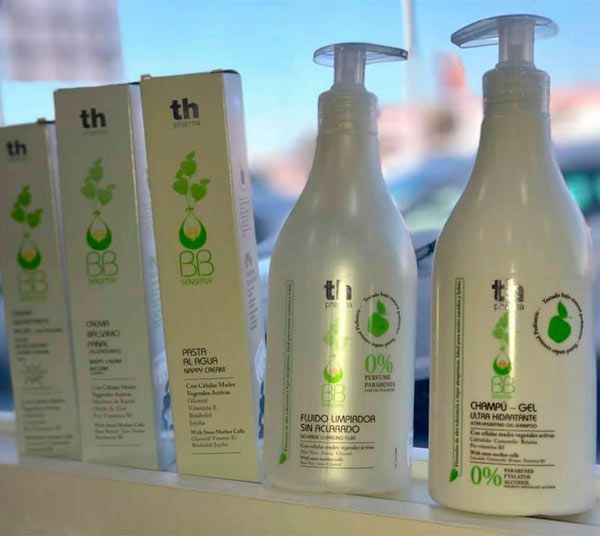 Varias botellas de cosméticos están alineadas en un estante.