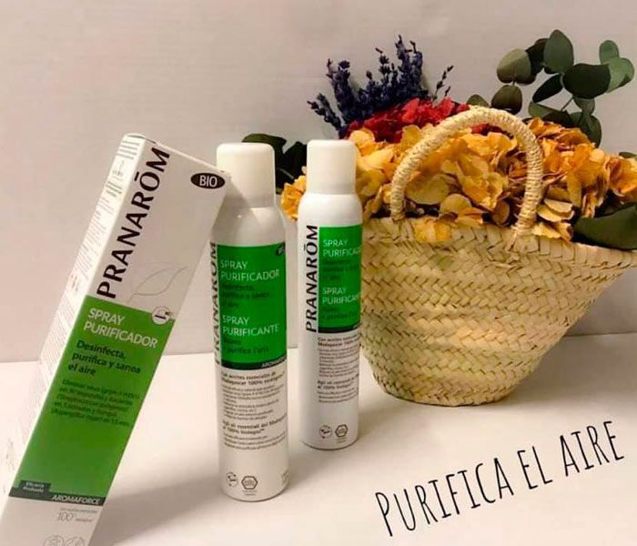 Dos botellas de spray Pranarom junto a una cesta de flores.