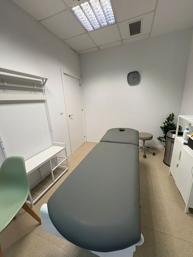 Hay una mesa de masajes en el medio de la habitación.