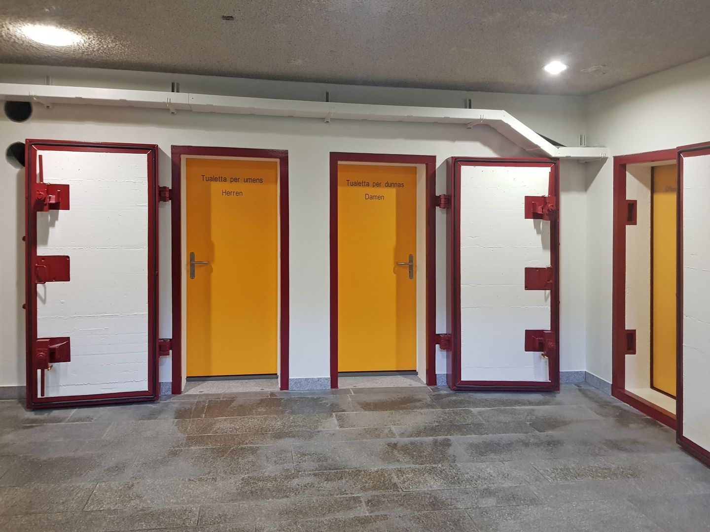 Eine Reihe gelber Türen in einem Raum mit weißen Wänden