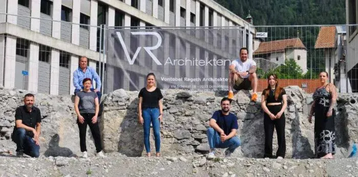 Eine Gruppe von Menschen posiert vor einem Gebäude für ein Foto.