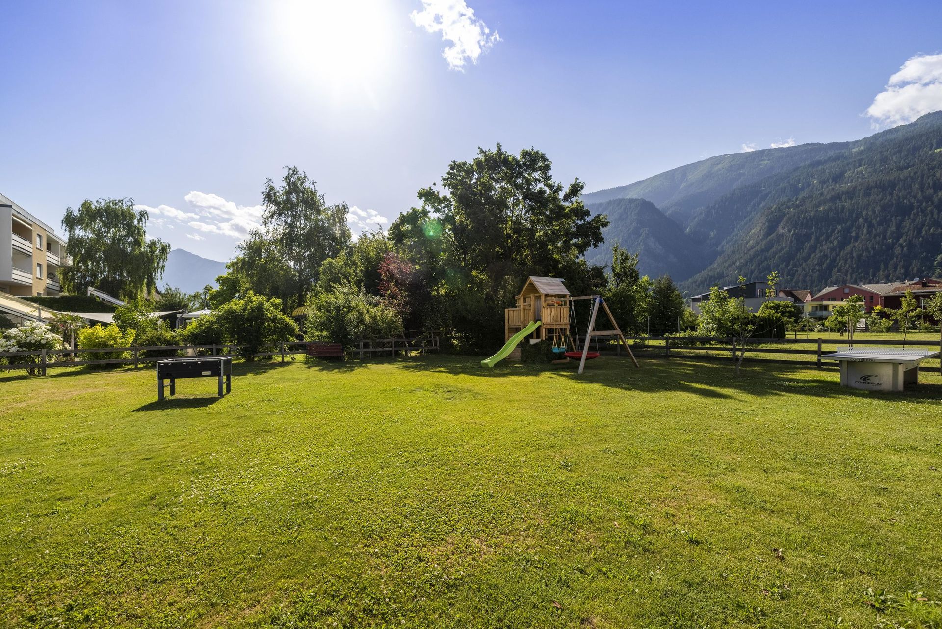 Inmitten einer üppigen grünen Wiese gibt es einen Spielplatz.