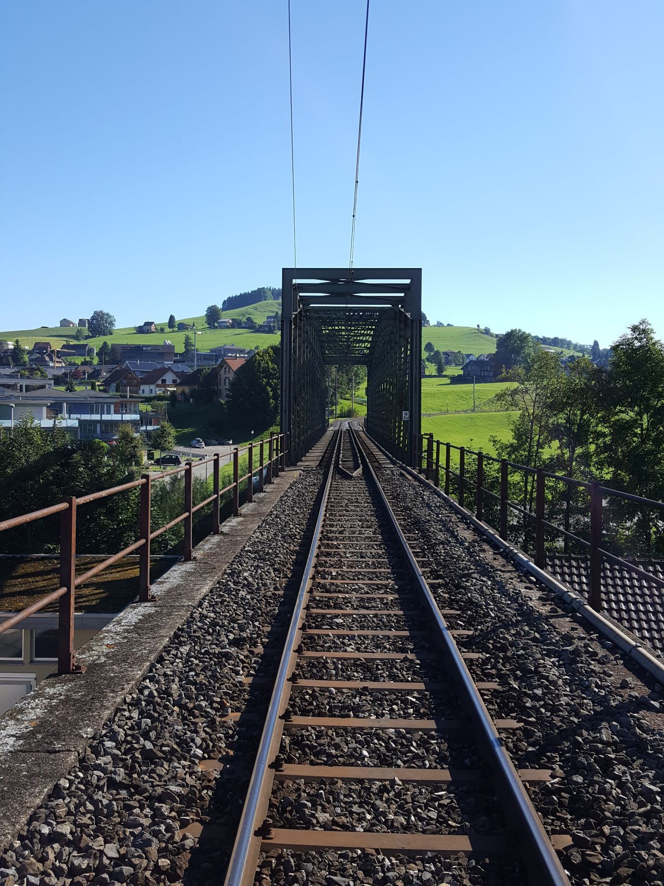 Eine Bahnstrecke mit einer Brücke im Hintergrund