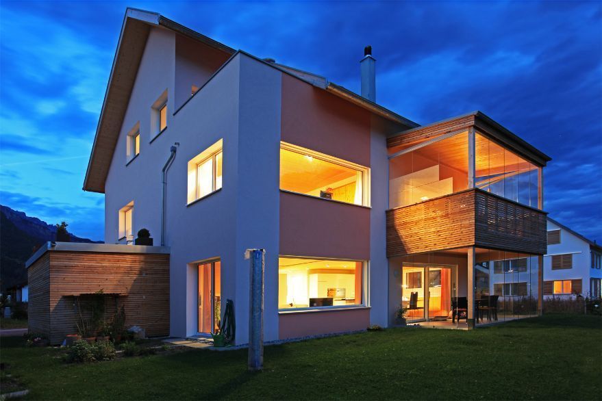 Ein großes Haus mit vielen Fenstern ist nachts beleuchtet