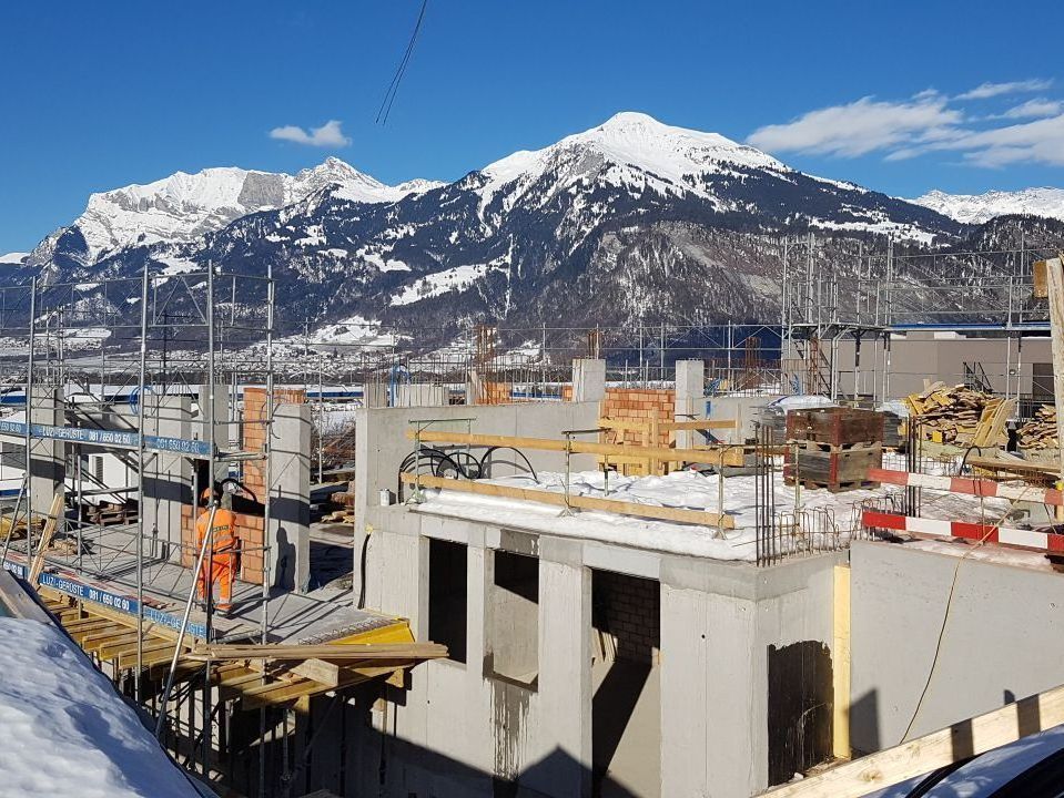 Eine Baustelle mit schneebedeckten Bergen im Hintergrund