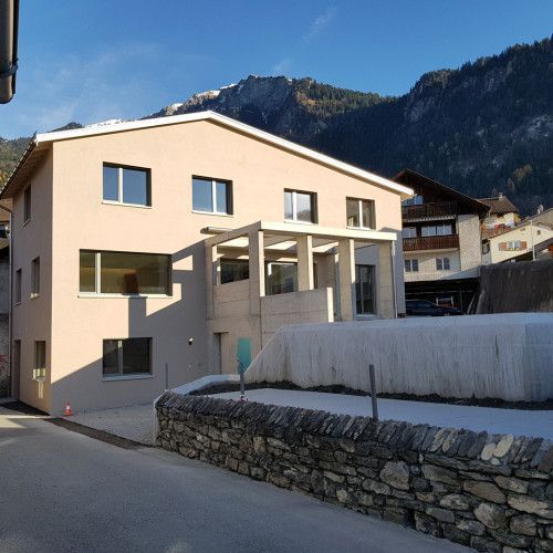 Ein großes Haus mit einer Steinmauer davor