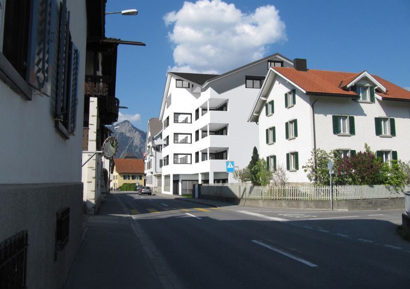 Ein weißes Gebäude mit rotem Dach steht neben einem anderen Gebäude