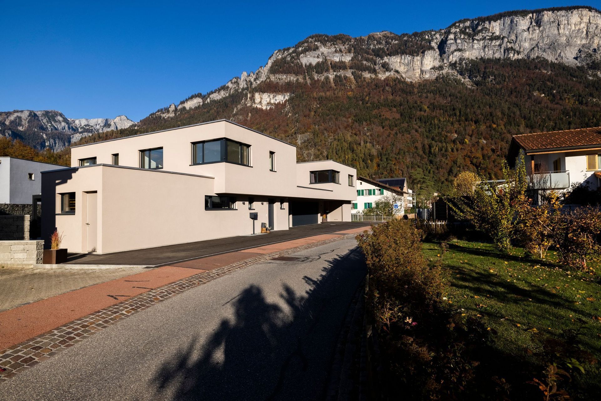 Ein Haus steht am Straßenrand mit Bergen im Hintergrund