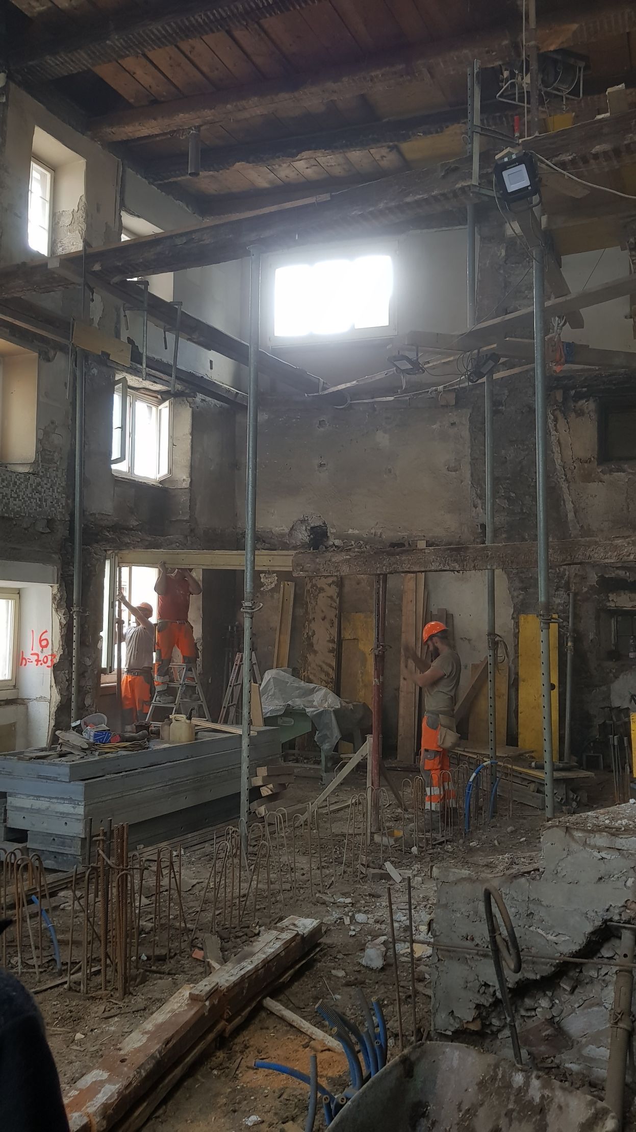 Ein großes Gebäude im Bau mit vielen Gerüsten und Arbeitern.