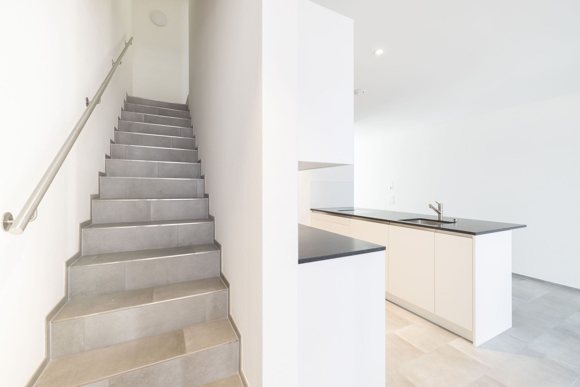 Eine Treppe, die in einem Haus zu einer Küche hinaufführt.