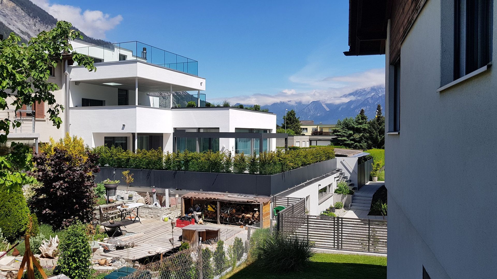 Ein großes weißes Haus mit Balkon und Bergen im Hintergrund