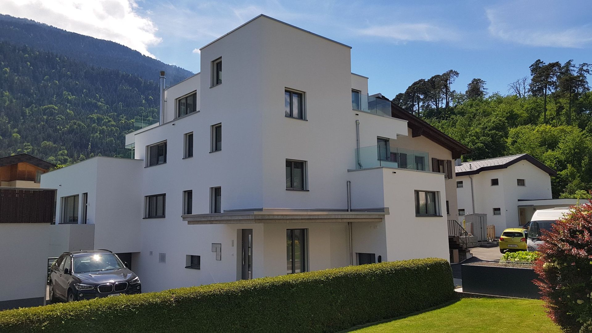 Ein weißes Gebäude mit einem davor geparkten Auto
