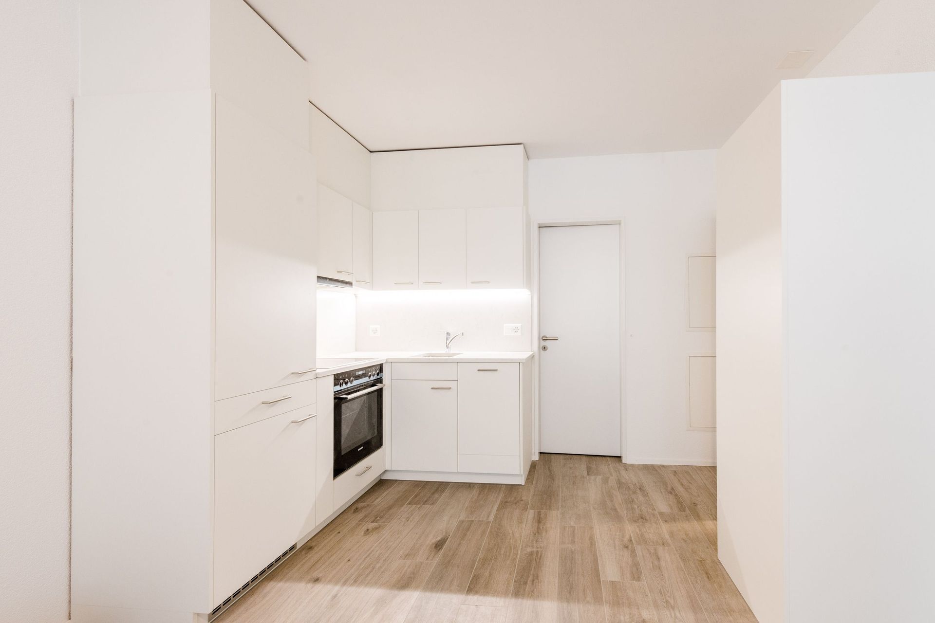 Eine Küche mit weißen Schränken und Holzböden