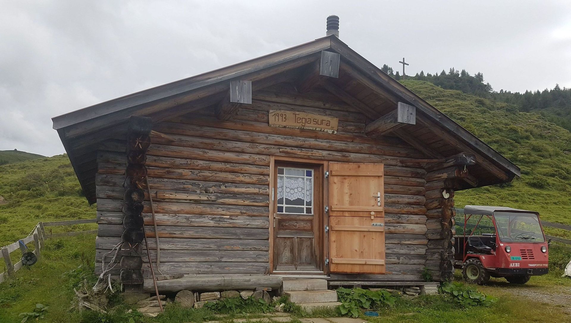 Eine kleine Holzhütte steht mitten auf einer Wiese.