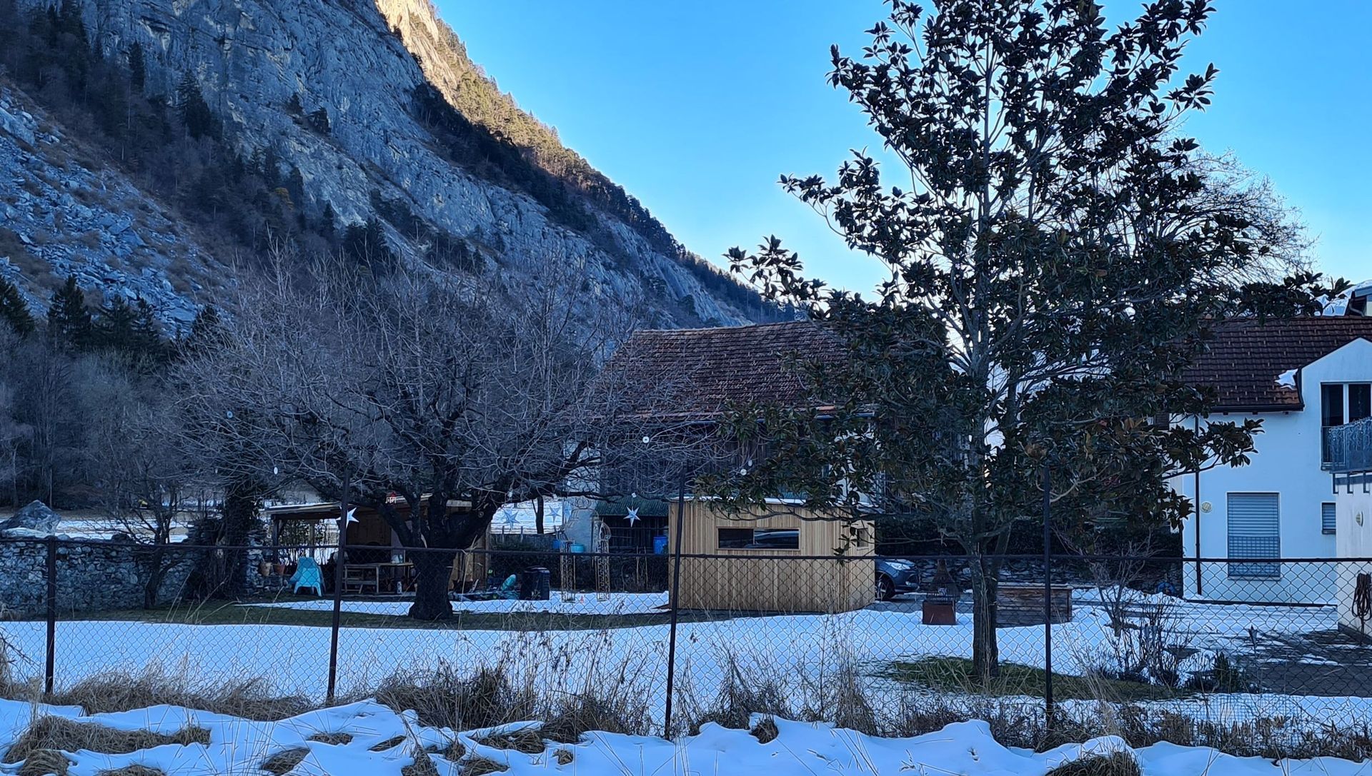 Ein schneebedecktes Feld mit einem Haus im Hintergrund