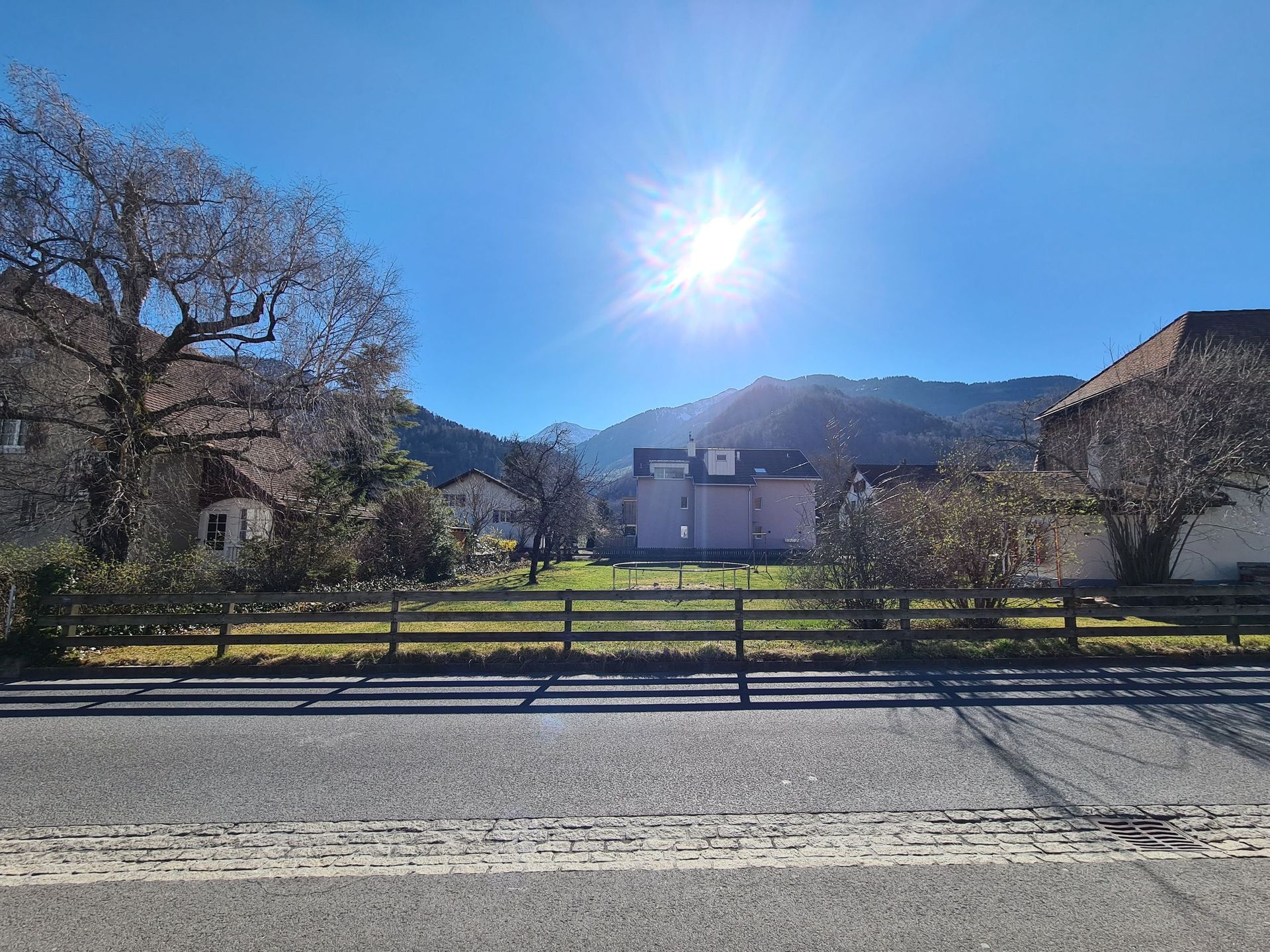 Die Sonne scheint hell über einem eingezäunten Hof