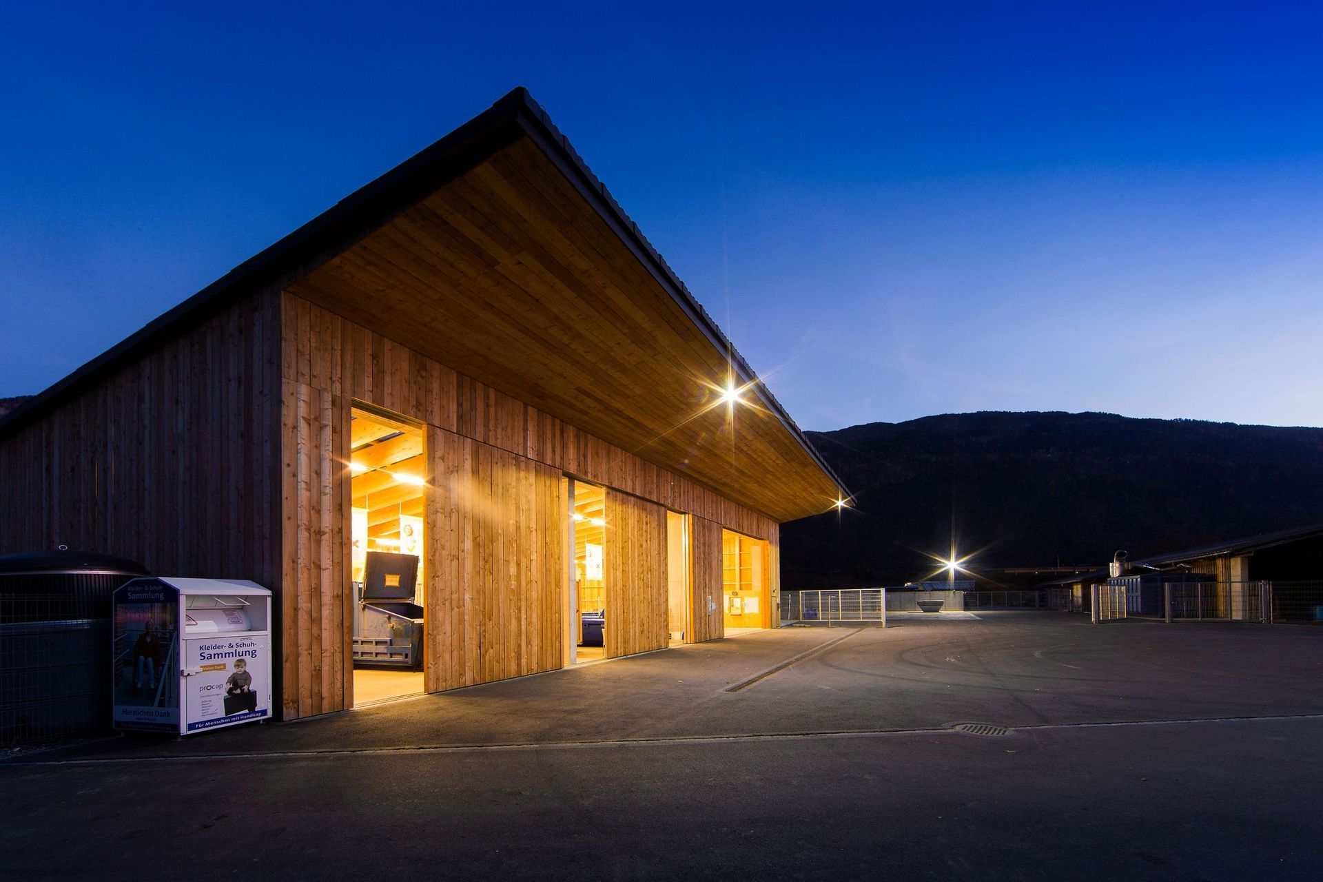 Ein großes Holzgebäude mit vielen Türen ist nachts beleuchtet