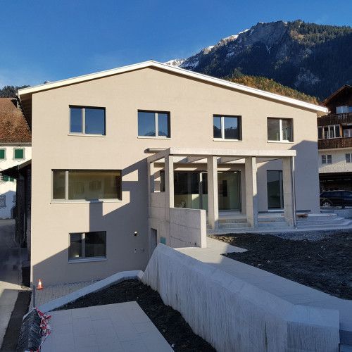 Ein großes weißes Haus mit einem Berg im Hintergrund