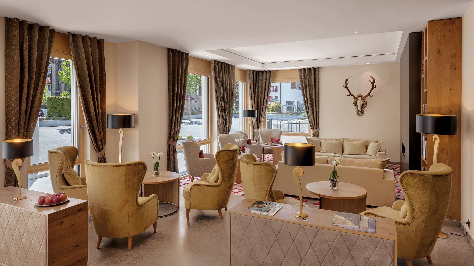 Ein Wohnzimmer voller Möbel und einem Hirschkopf an der Wand.