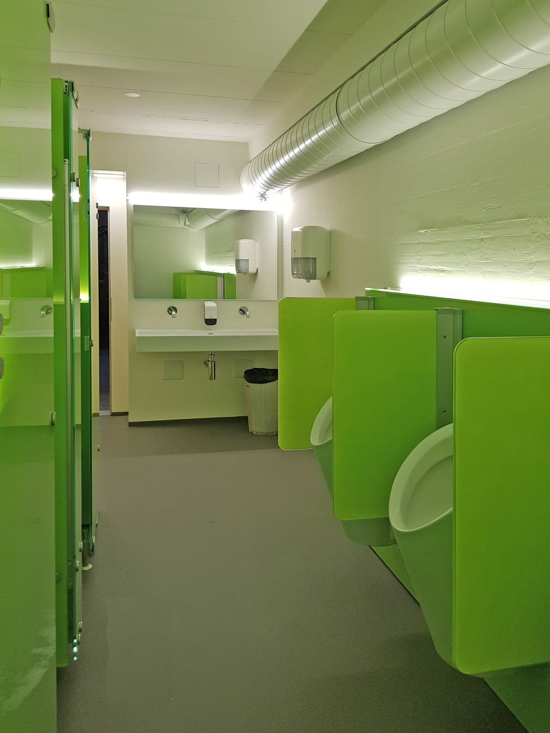 Ein Badezimmer mit grünen Kabinen und einem Waschbecken