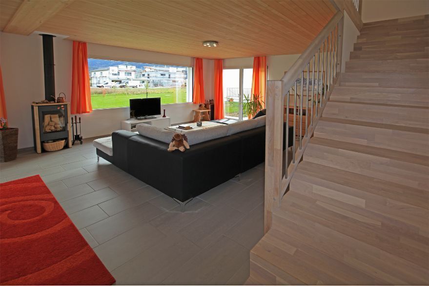 Ein Wohnzimmer mit Treppe zum zweiten Stock