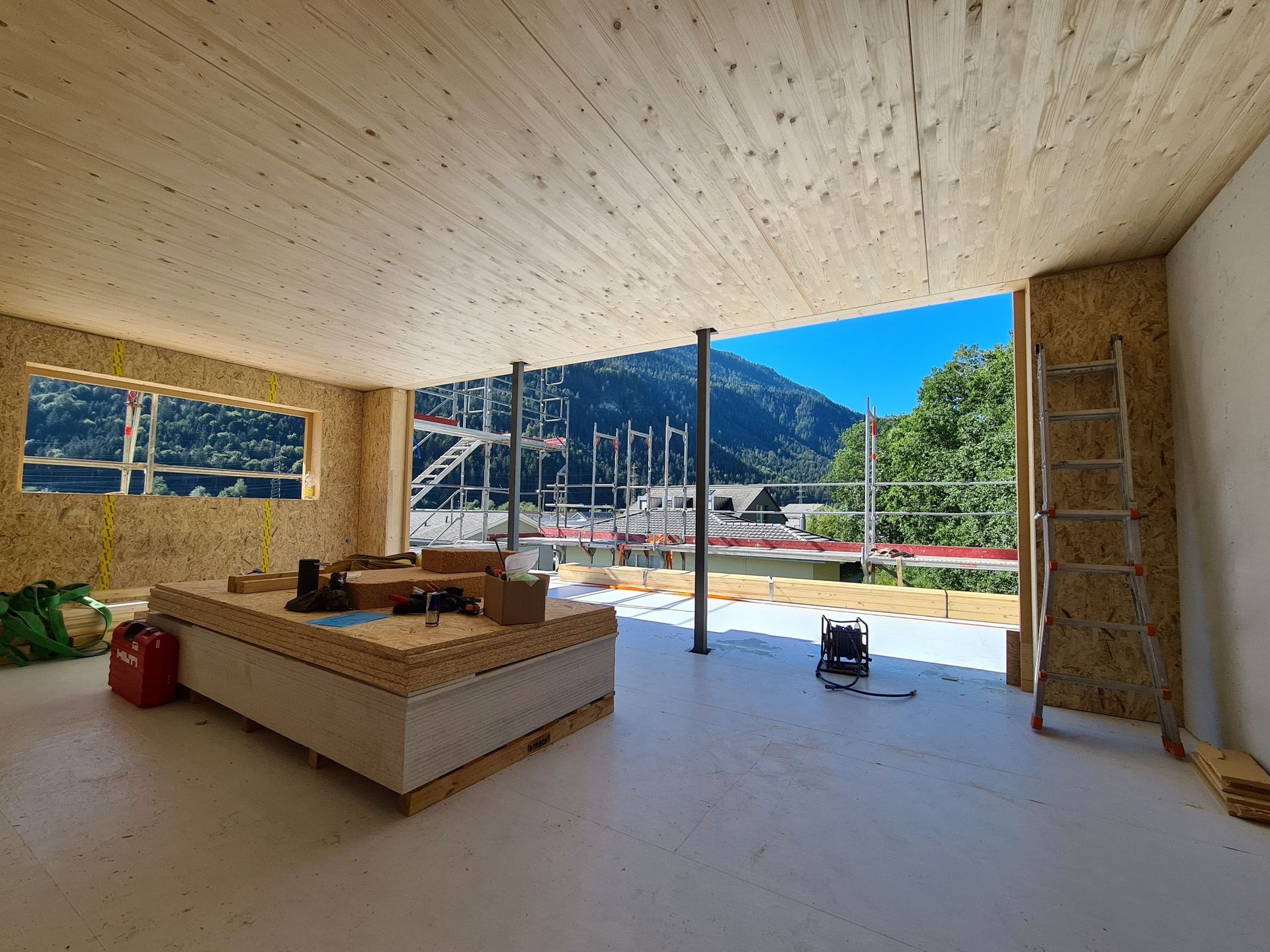 Ein Zimmer mit Holzdecke und Blick auf einen Berg.