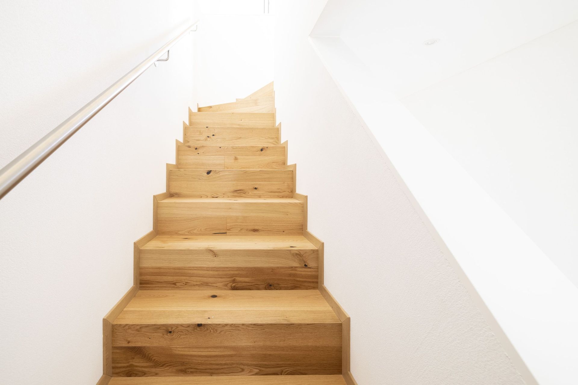 Eine Holztreppe, die in den zweiten Stock eines Hauses führt.
