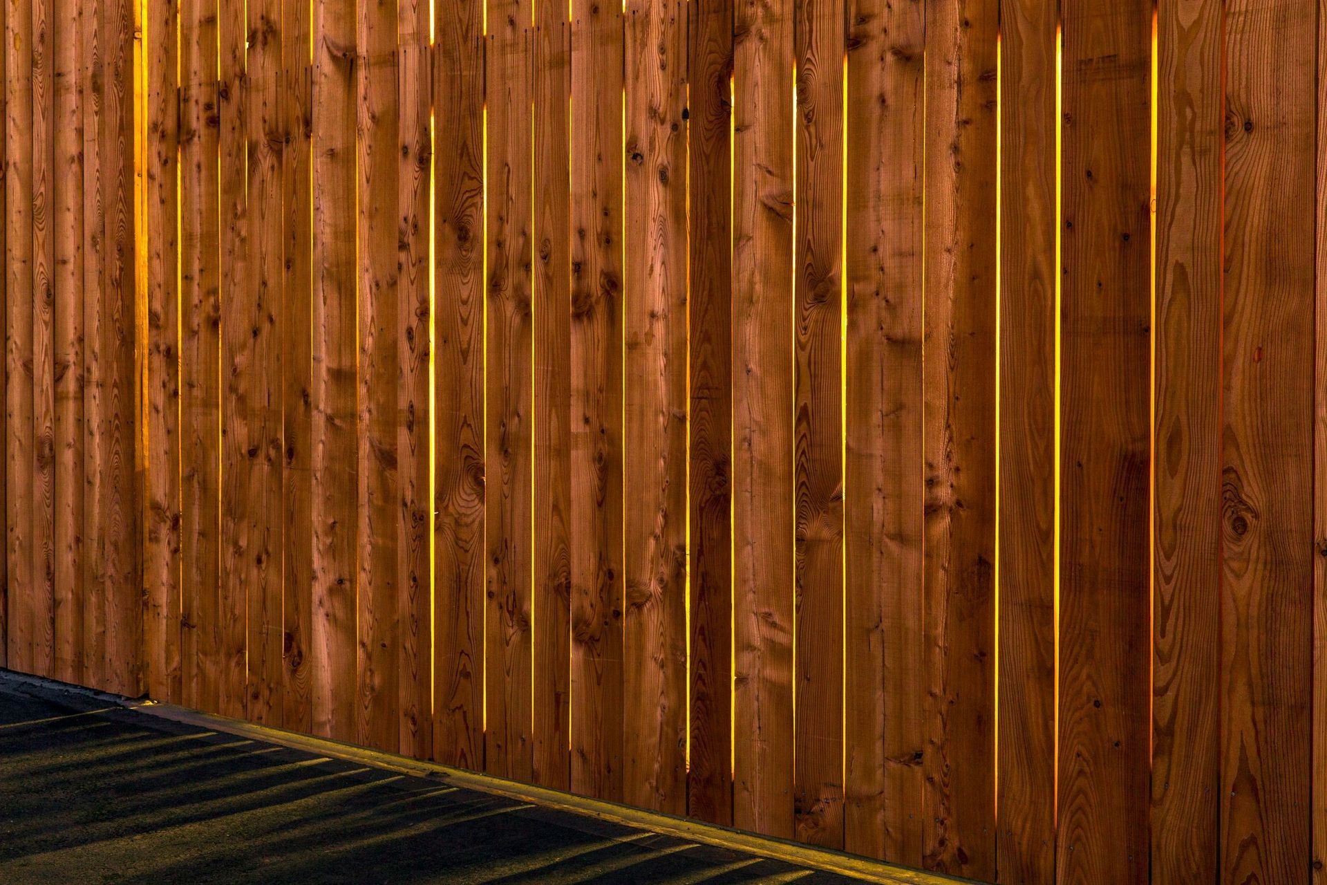 Eine Nahaufnahme eines Holzzauns auf einem Parkplatz.