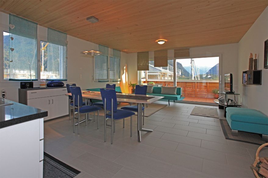 Ein Wohnzimmer mit Esstisch und Stühlen und einer Couch.