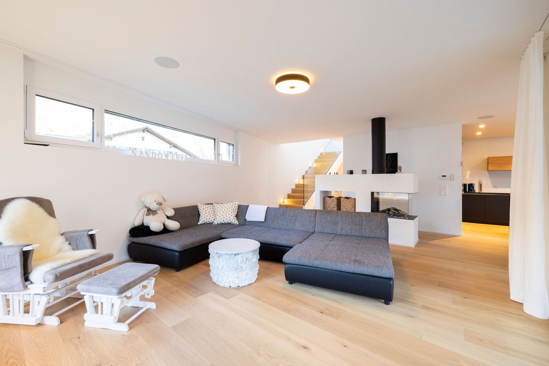 Ein Wohnzimmer mit Couch, Schaukelstuhl und Tisch.