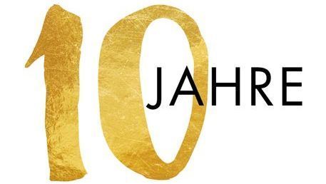 Die Zahl 10 ist in Gold auf weißem Grund geschrieben.
