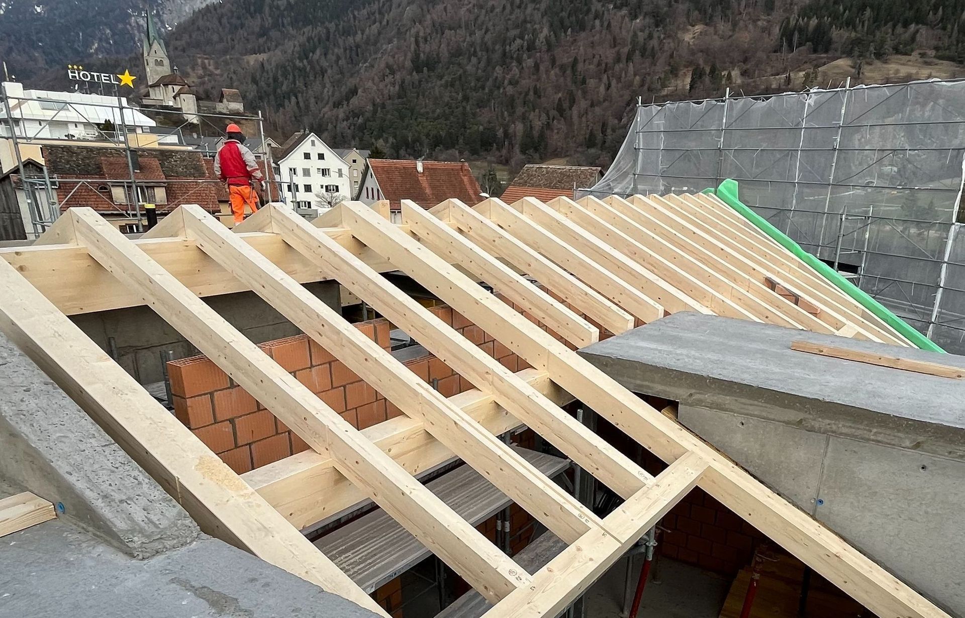 Ein Mann steht auf dem Dach eines im Bau befindlichen Gebäudes