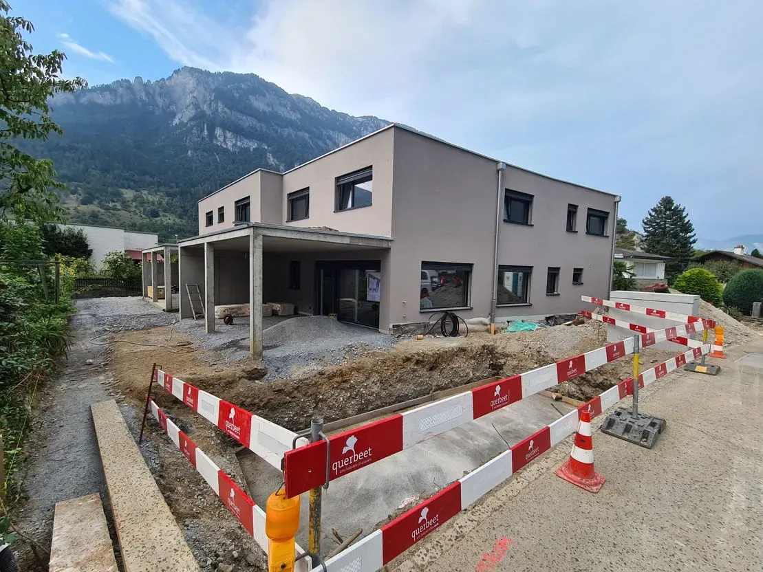 Ein im Bau befindliches Gebäude mit einem Berg im Hintergrund.