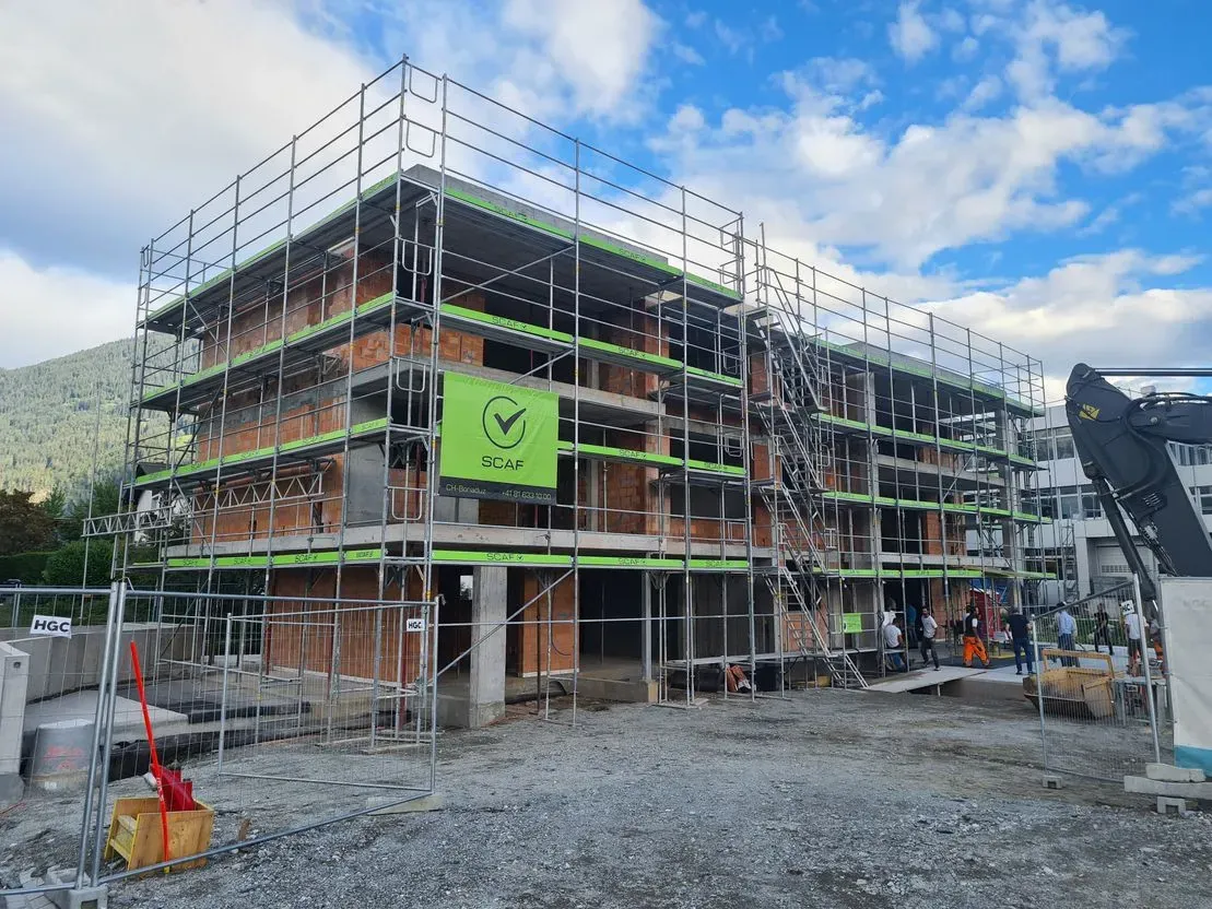 Es wird ein großes Gebäude errichtet, das von einem Gerüst umgeben ist.