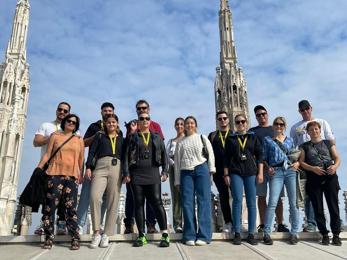 Eine Gruppe von Menschen posiert auf einem Gebäude für ein Foto.