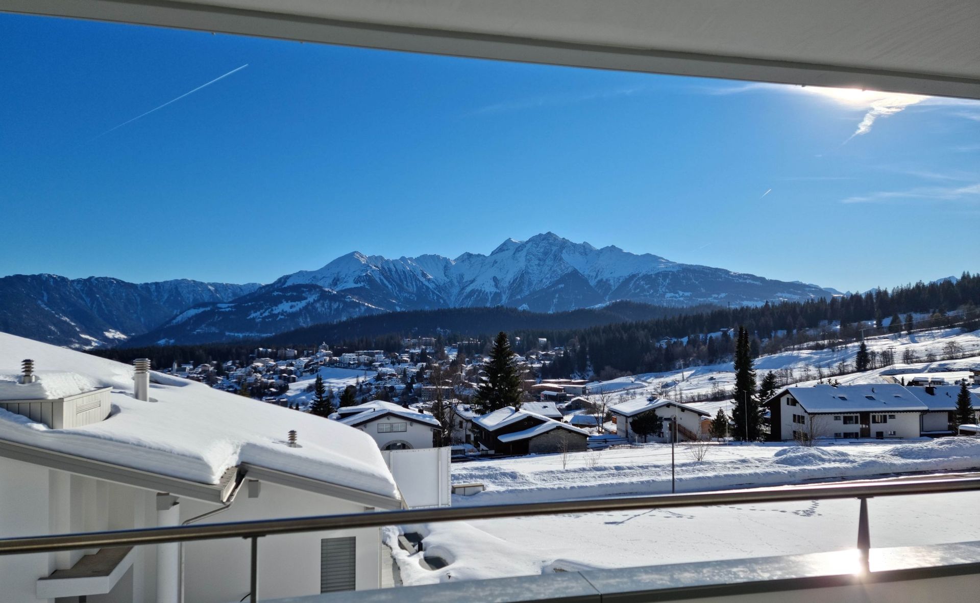 Ein Blick auf eine schneebedeckte Bergkette von einem Balkon aus.