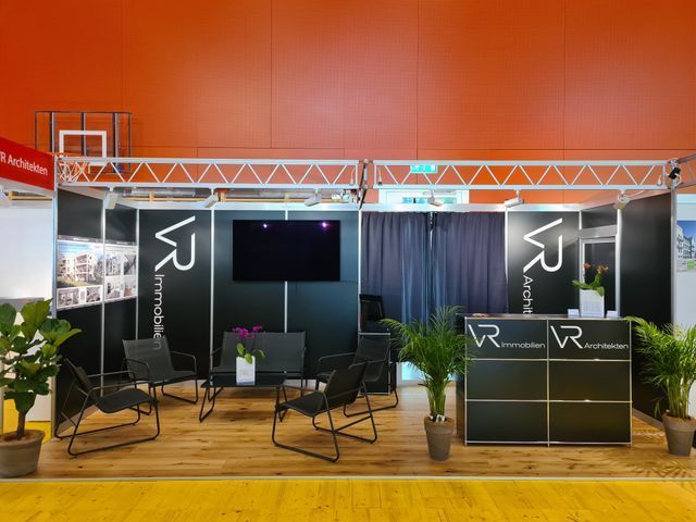 Eine Sitznische mit Stühlen und einem Fernseher an der Wand.