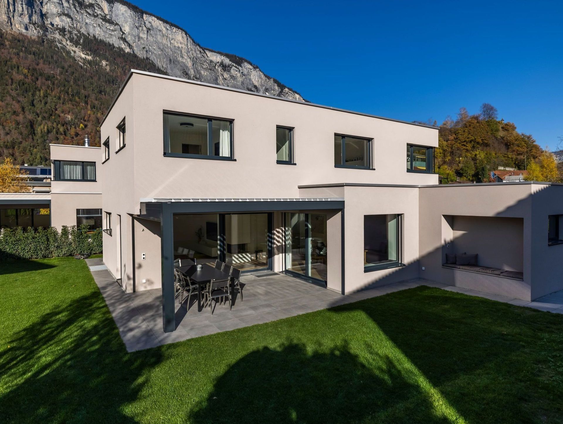 Ein Haus mit Terrasse und Bergen im Hintergrund