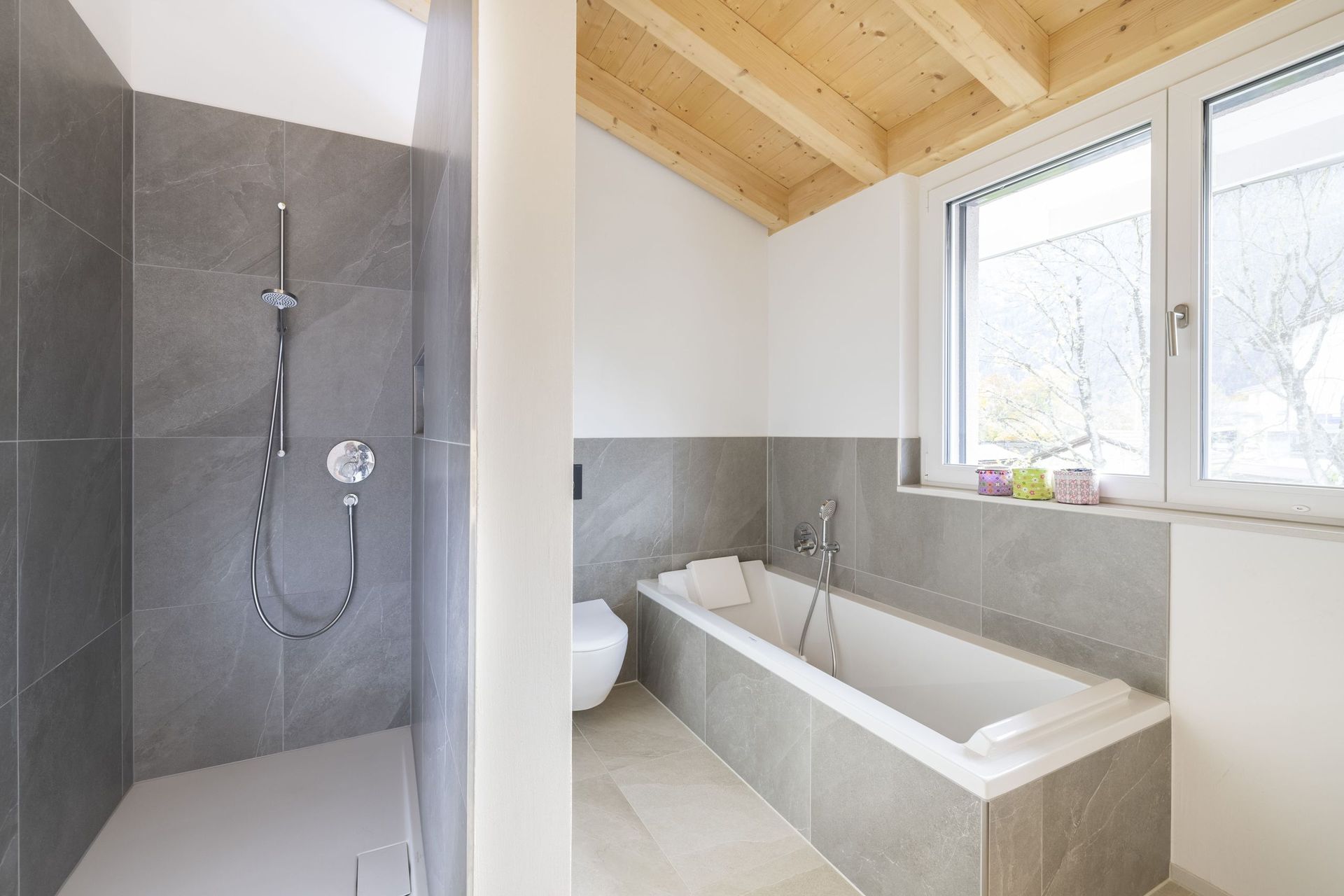 Ein Badezimmer mit Badewanne, Dusche, WC und Fenster.