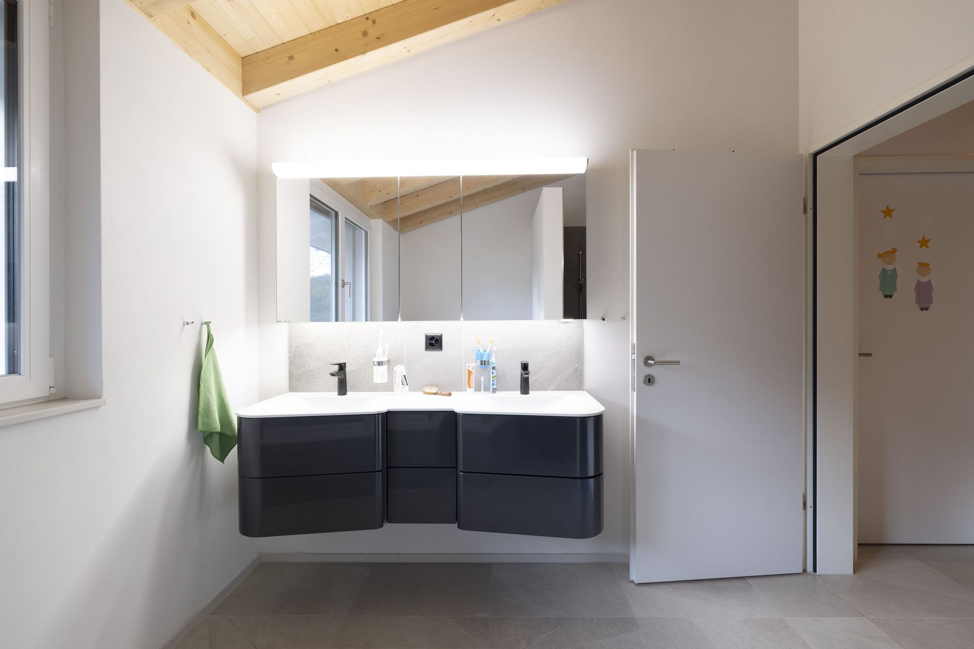 Ein Badezimmer mit zwei Waschbecken und einem Spiegel.