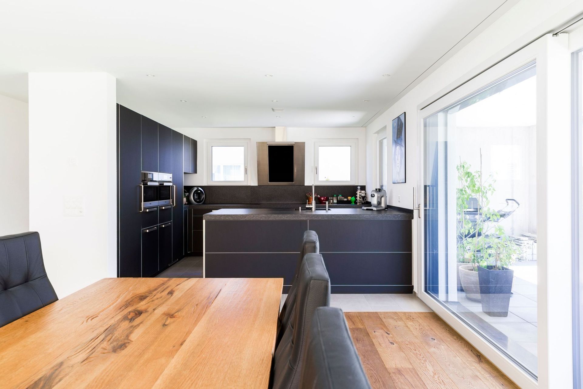 Eine Küche mit einem Holztisch und Stühlen und einer Glasschiebetür.