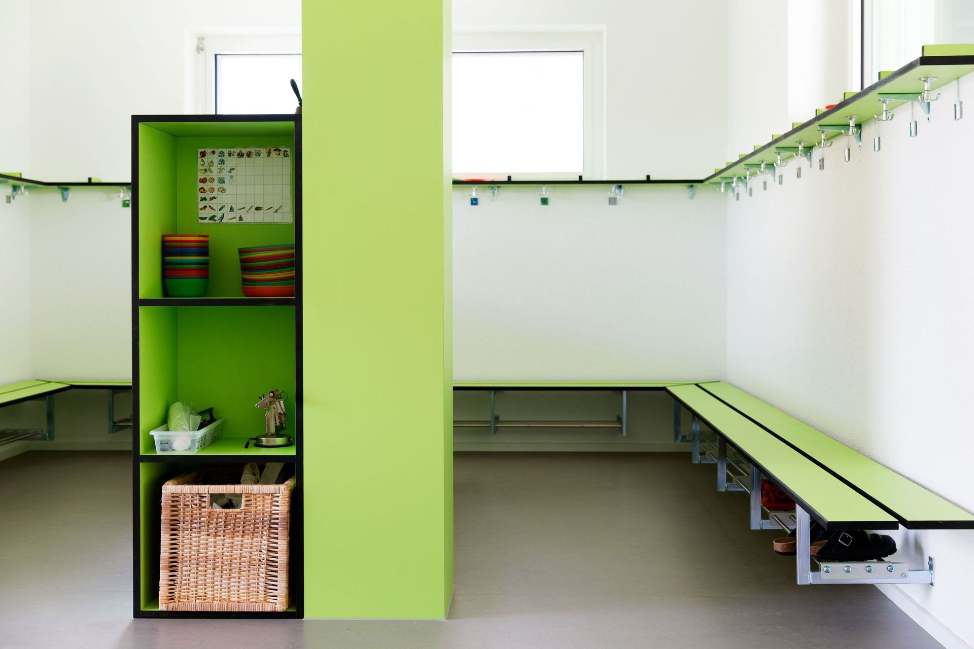 Eine Umkleidekabine mit grünen Regalen und einer grünen Bank