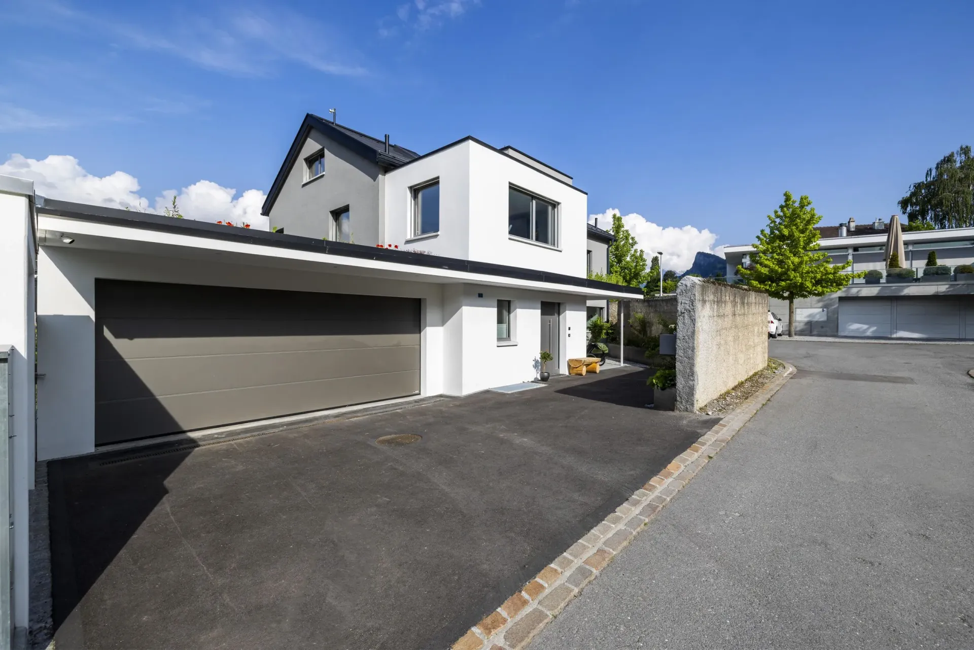 Ein großes weißes Haus mit Garage und Einfahrt