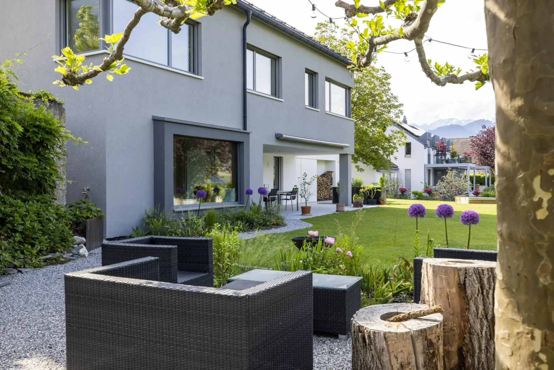 Ein Haus mit Rasen und Stühlen davor